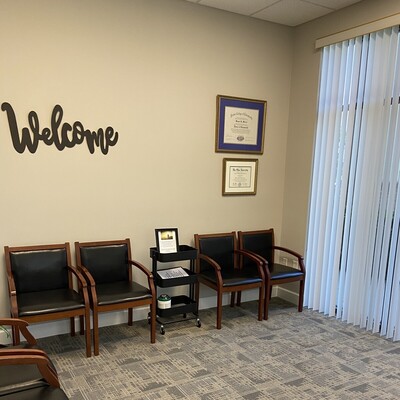Waiting room at Kissimmee Family Wellness Center with diplomas and guest seating.